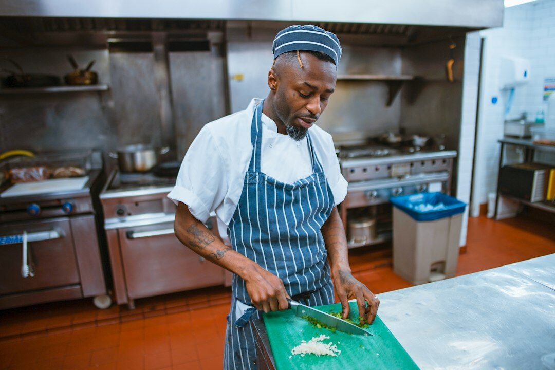 person chopping vegetables in kitchen